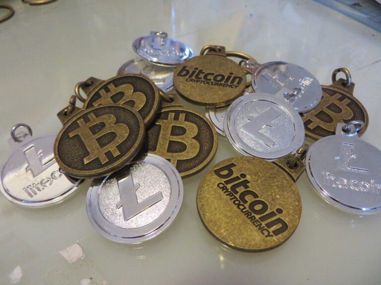 Pieces physiques representant des cryptomonnaies bitcoin et litecoin posees sur une surface sombre