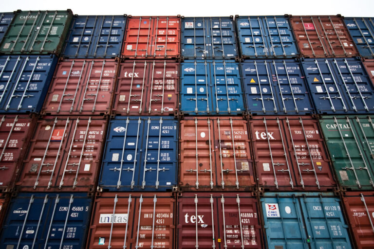 Conteneurs de fret multicolores empilés dans un port de commerce
