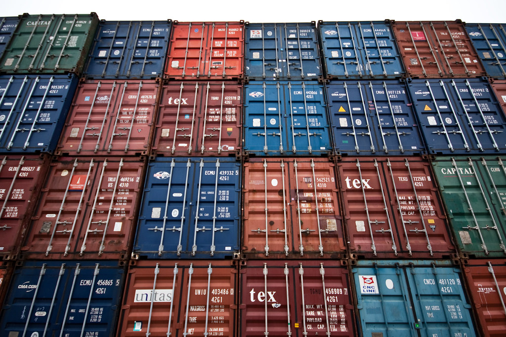 Conteneurs de fret multicolores empilés dans un port de commerce