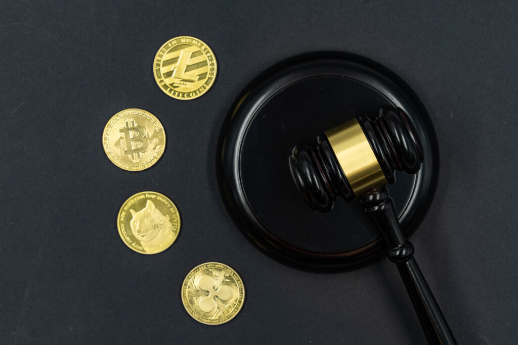Pieces de cryptomonnaie posees sur un texte reglementaire imprime