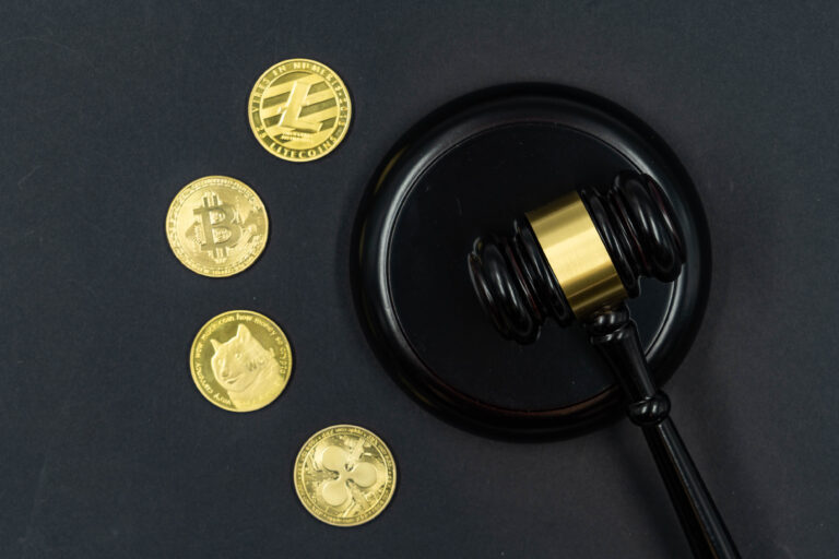 Pieces de cryptomonnaie posees sur un texte reglementaire imprime